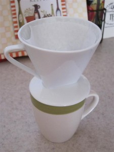 Put the dripper on top of the coffee cup Put the dripper on top of the coffee cup